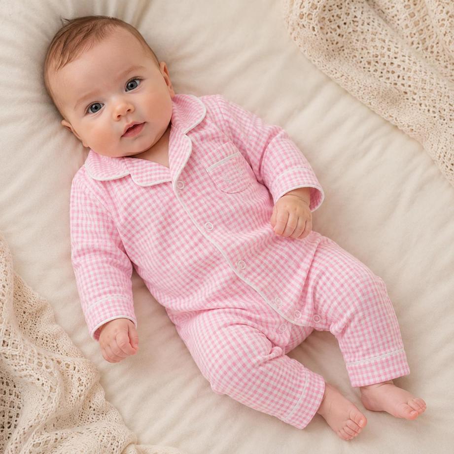 Bebê usando macacão pijama xadrez rosa
